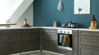 Nowoczesna kuchnia z szarymi frontami szafek i turkusową ścianą. Idealna inspiracja, jaka farba do kuchni nada jej elegancji.