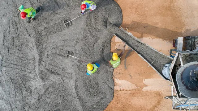 Pracownicy wylewają beton z betoniarki. Zastanawiasz się, ile kosztuje m3 betonu?
